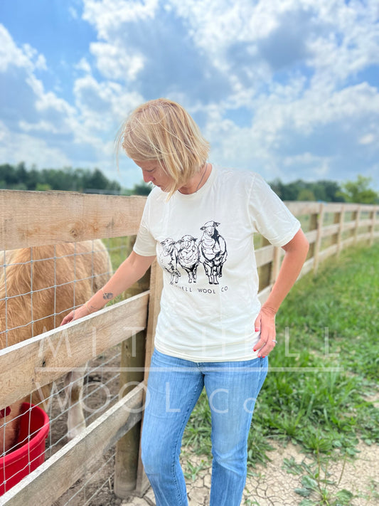 Sherry stands next to our highland cow Blair who nibbles from a vitamin bucket. Her face is screwed in consternation over the drought. At least she has this organic cotton tee shirt emblazened with the Mitchell flock on it to keep her spirits up!
