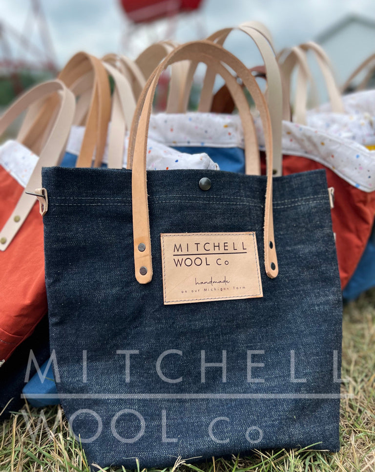A simple raw denim tote with vegetable tanned natural handles
