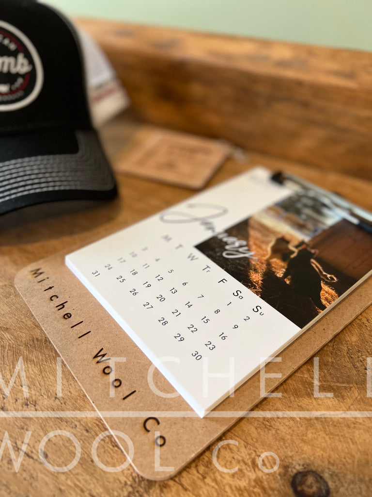 a Mitchell Wool calendar sits on a pine table 