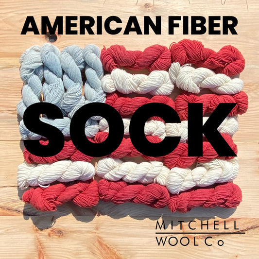 an American flag composed of yarn with the words American Fiber sock in black on the surfaces.