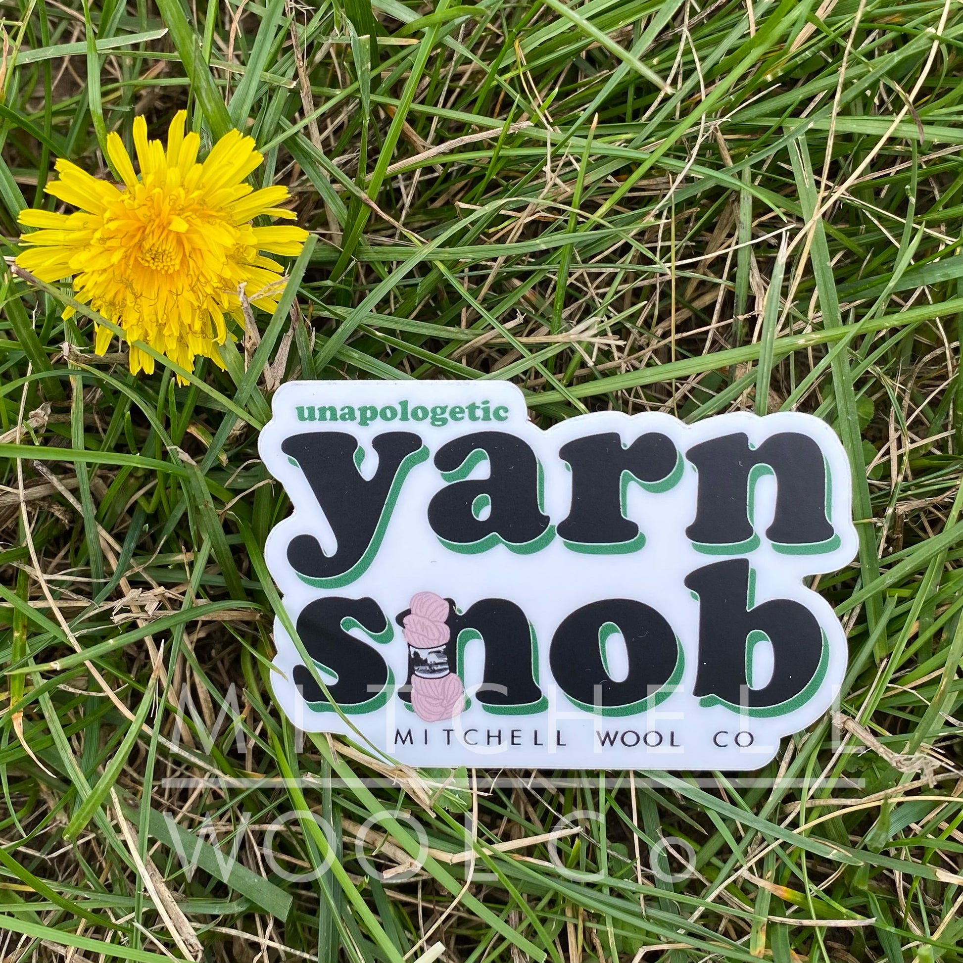 die cut 2.91x2" sticker with black and green saying "unapologetic yarn snob" with a light pink yarn skein on the "n"