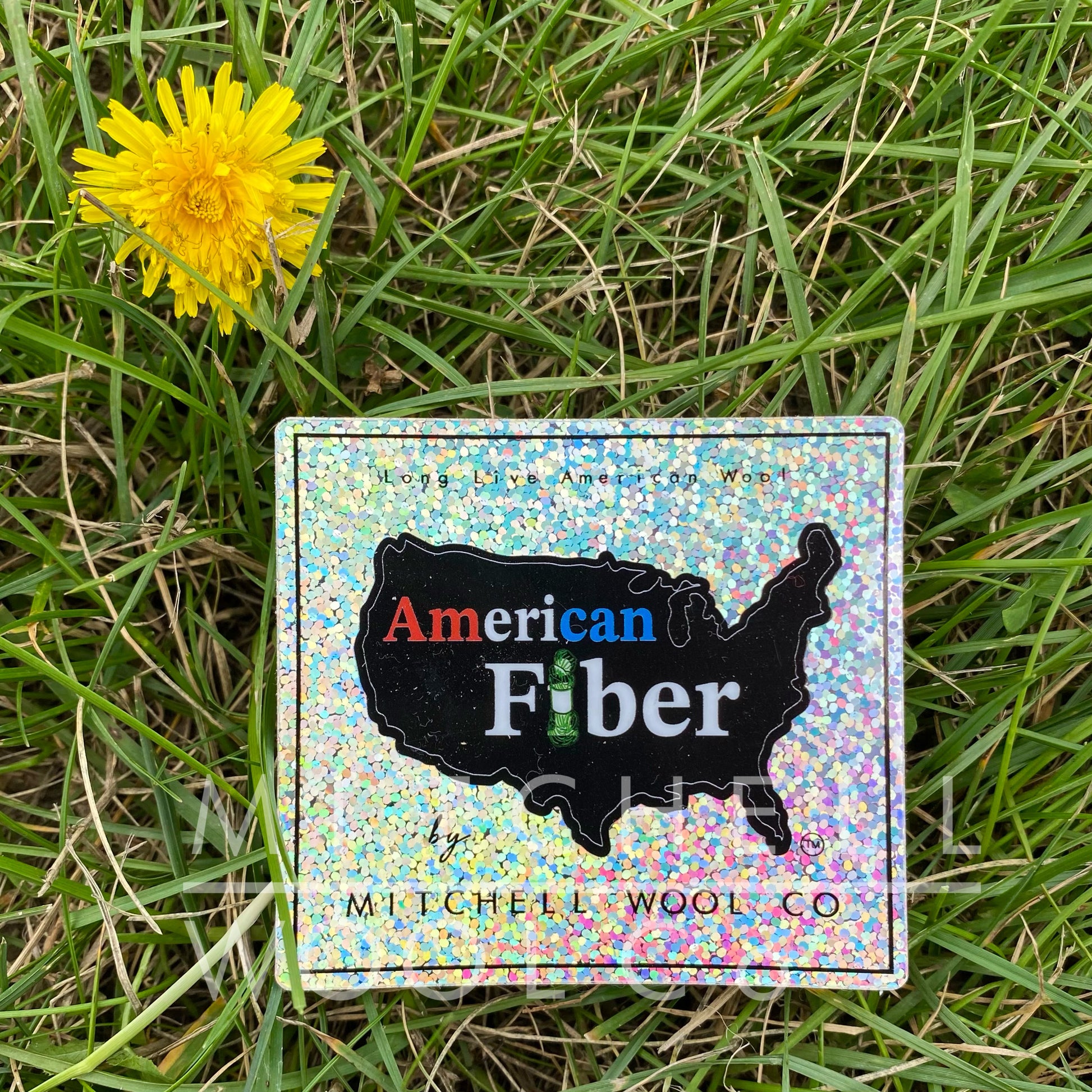 mulitcolored glitter rounded cornered 3" square sticker, with silhouette of United States that reads " american fiber, mitchell wool co" 