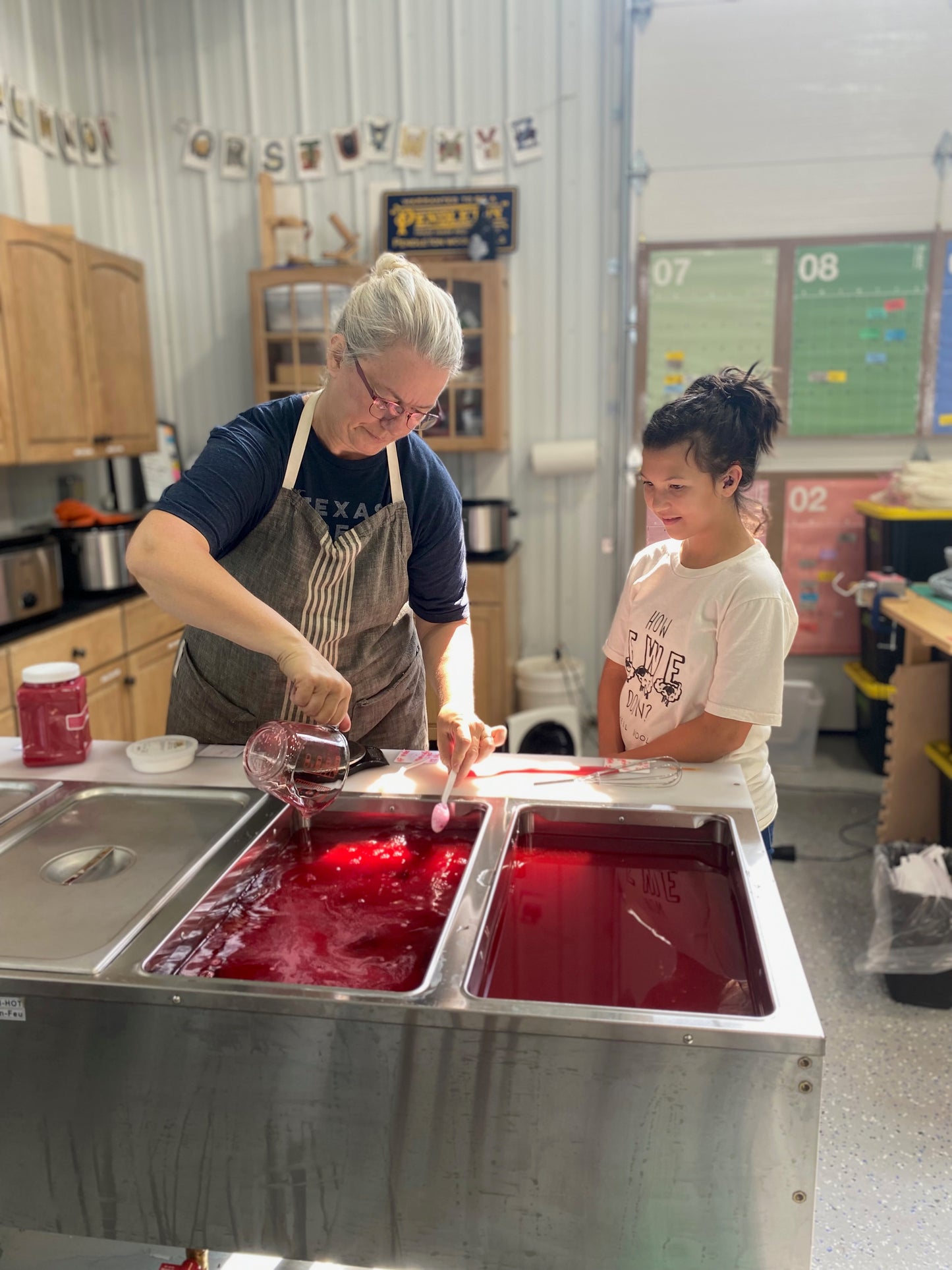 Cindy prepares a pot of dye while her granddaughter looks on