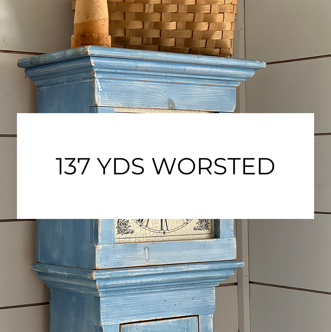 A photo of a blue swedish pine clock with the words 137 YDS Worsted
