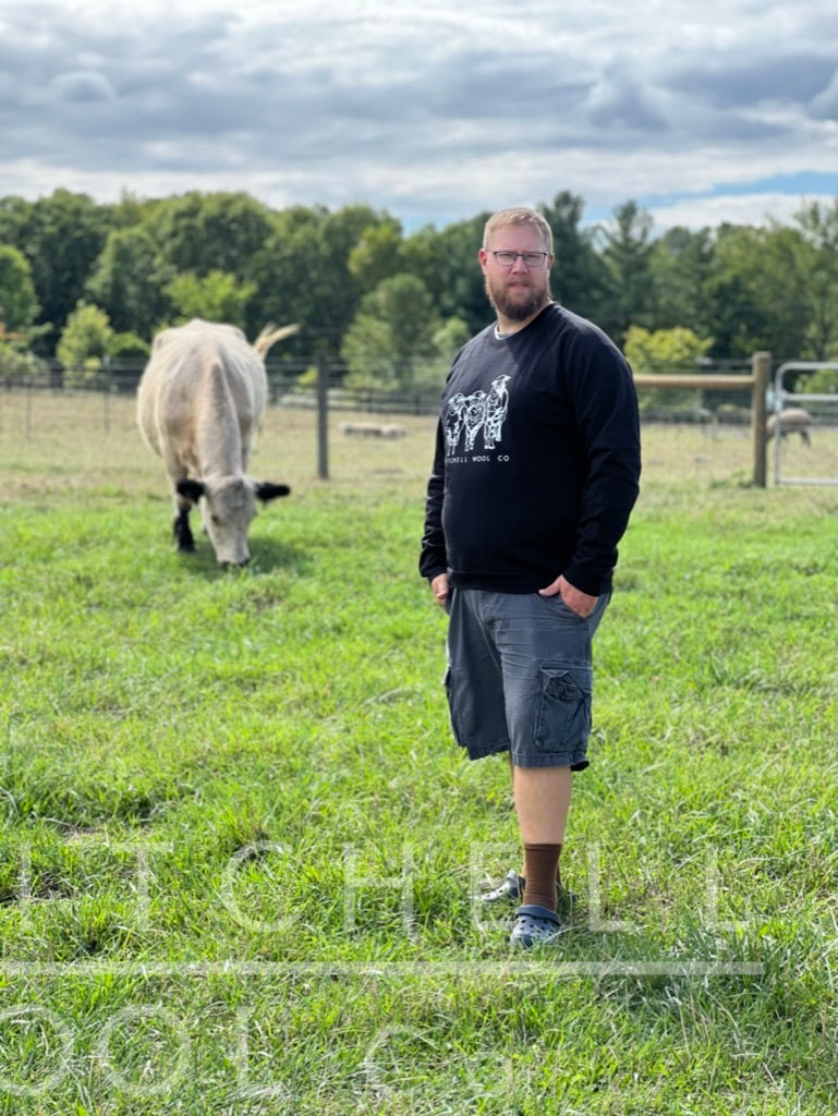 Luke stands in the pasture in front of Dorothy who happily munches the fresh grass she was turned out onto this morning. He wears a black organic cotton sweatshirt in size XXL which fits his 54" chest nicely.