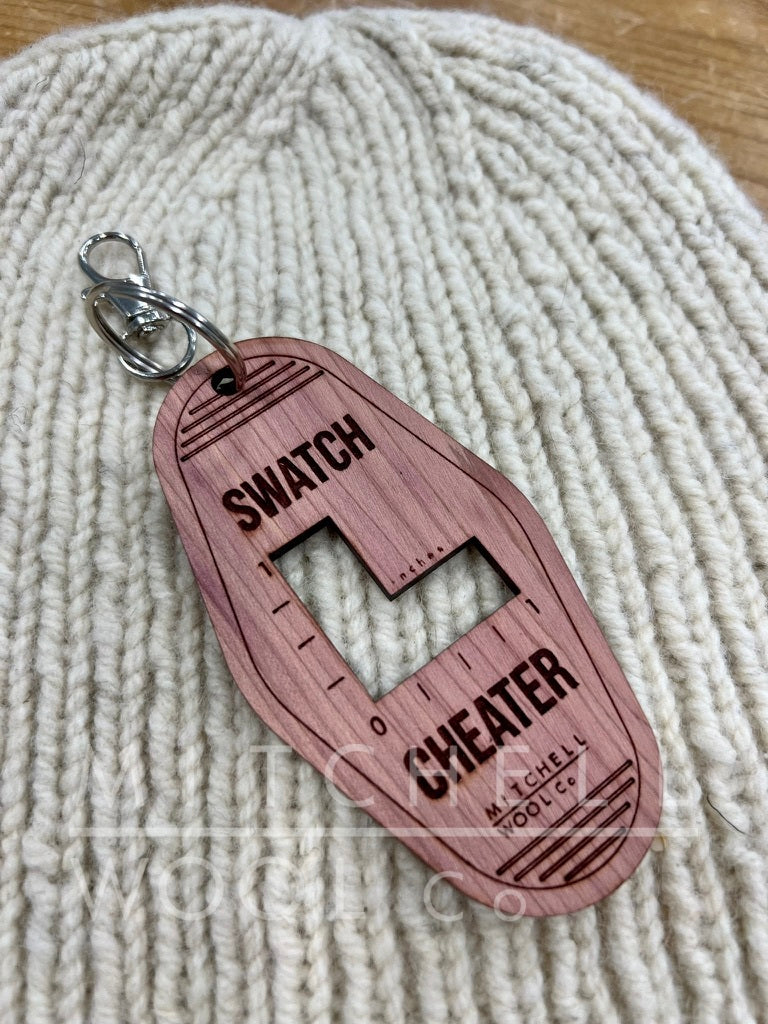Cedar key chain with lobster claw clasp that has the words Swatch Cheater engraved as well as a 1x1" cut out for cheating at your swatch game. Not that we advise that. But (Sherry is a big ol cheater punkin eater)
