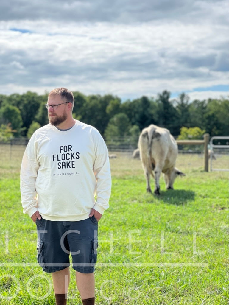 Luke stands in the foreground of our cattle pasture. Dorothy munches pasture behind him. He wears a size 3XL nature organic cotton sweatshirt.