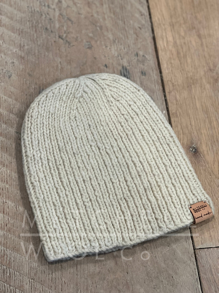 Deep Breath Hat hand knit in white cormo worsted by our dear Friend Catherine  sits on aged oak barn floorboards