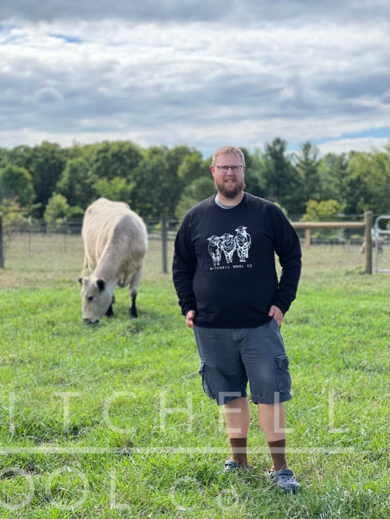 Luke stands in the pasture in front of Dorothy who happily munches the fresh grass she was turned out onto this morning. He wears a black organic cotton sweatshirt in size XXL which fits his 54" chest nicely. We're not going to talk about those weird brown half calf socks he's sporting with his shop crocs