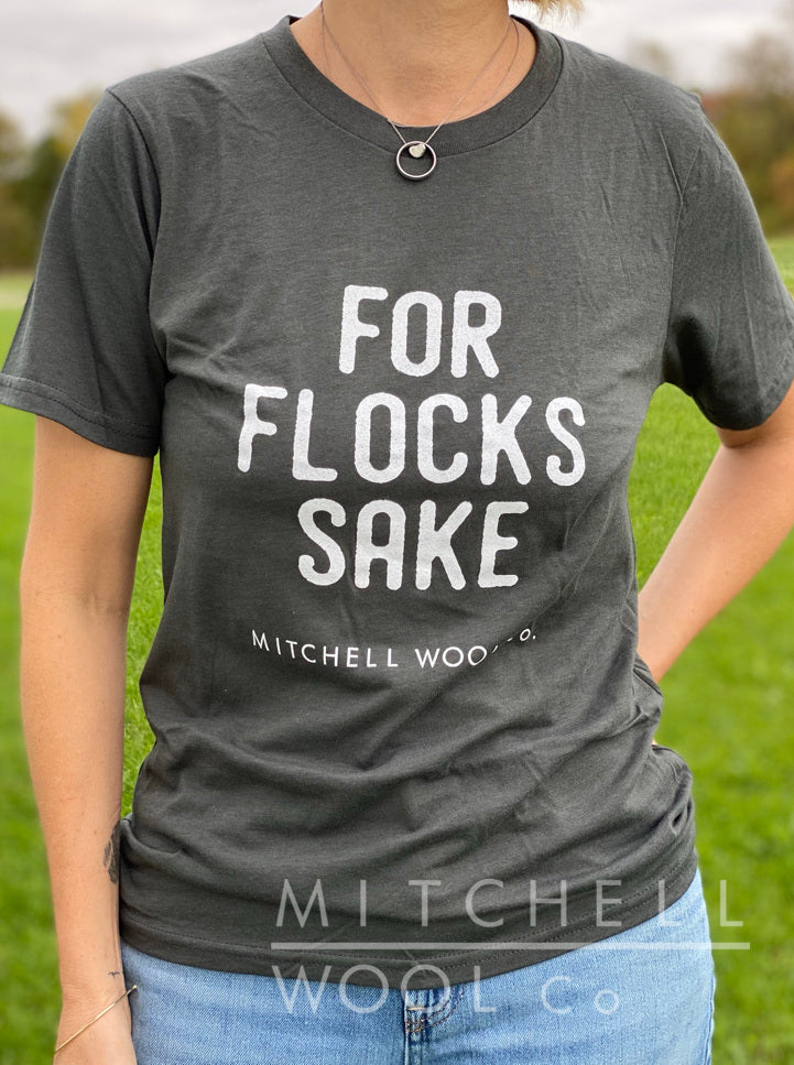 Sherry stands in a pasture wearing a Slate For Flocks Sake organic cotton tee shirt and faded jeans