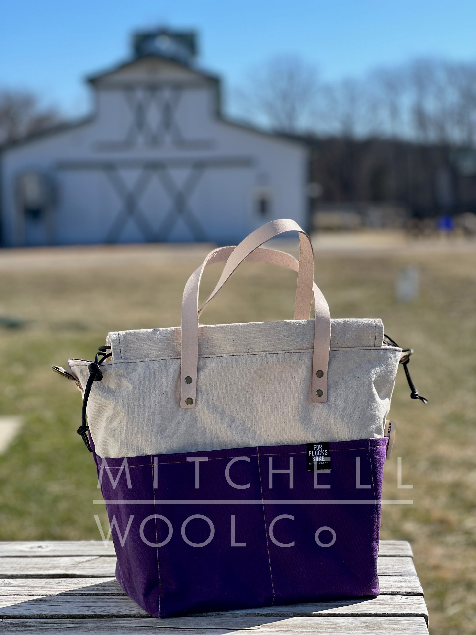 Bekah loves Purple sweater bag sits on a wood table in front of the lambing barn