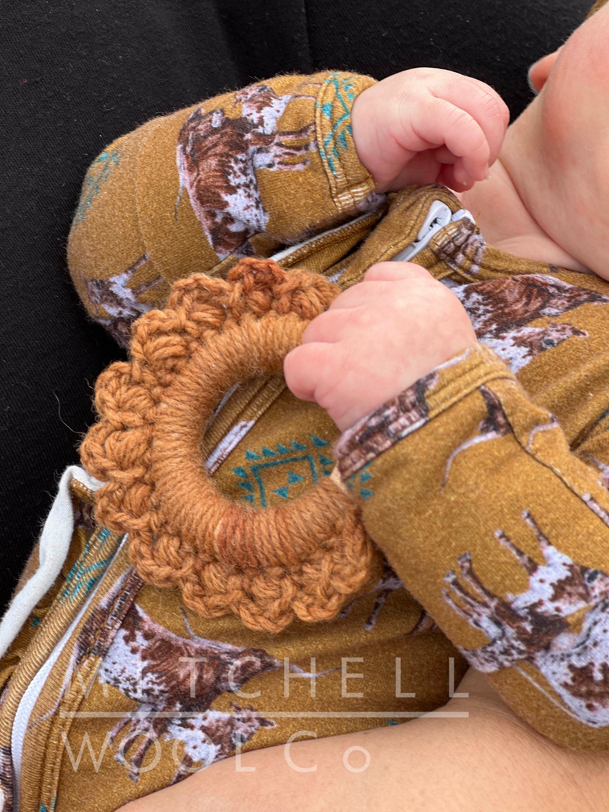 Sweet little punkin clutches a hand crocheted teether 