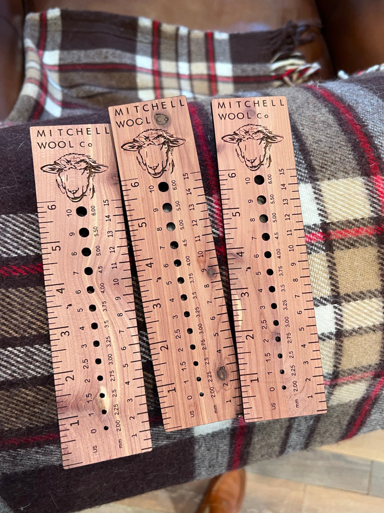 three cedar rulers with the Mitchell Wool logo and a sketch of Veda provide needle gauge holes in sizes 0 - 10