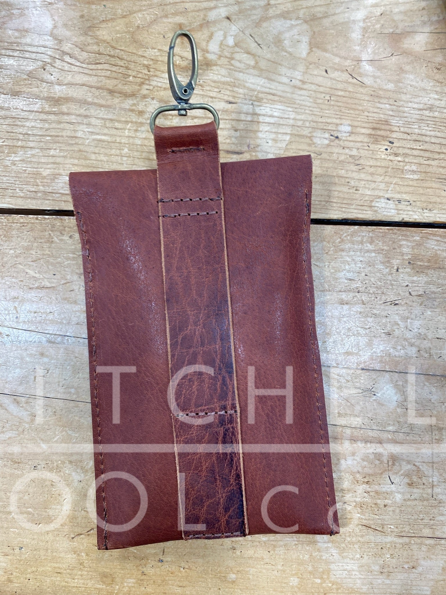 Back side of cell phone pouch that features two slots for your belt or tack