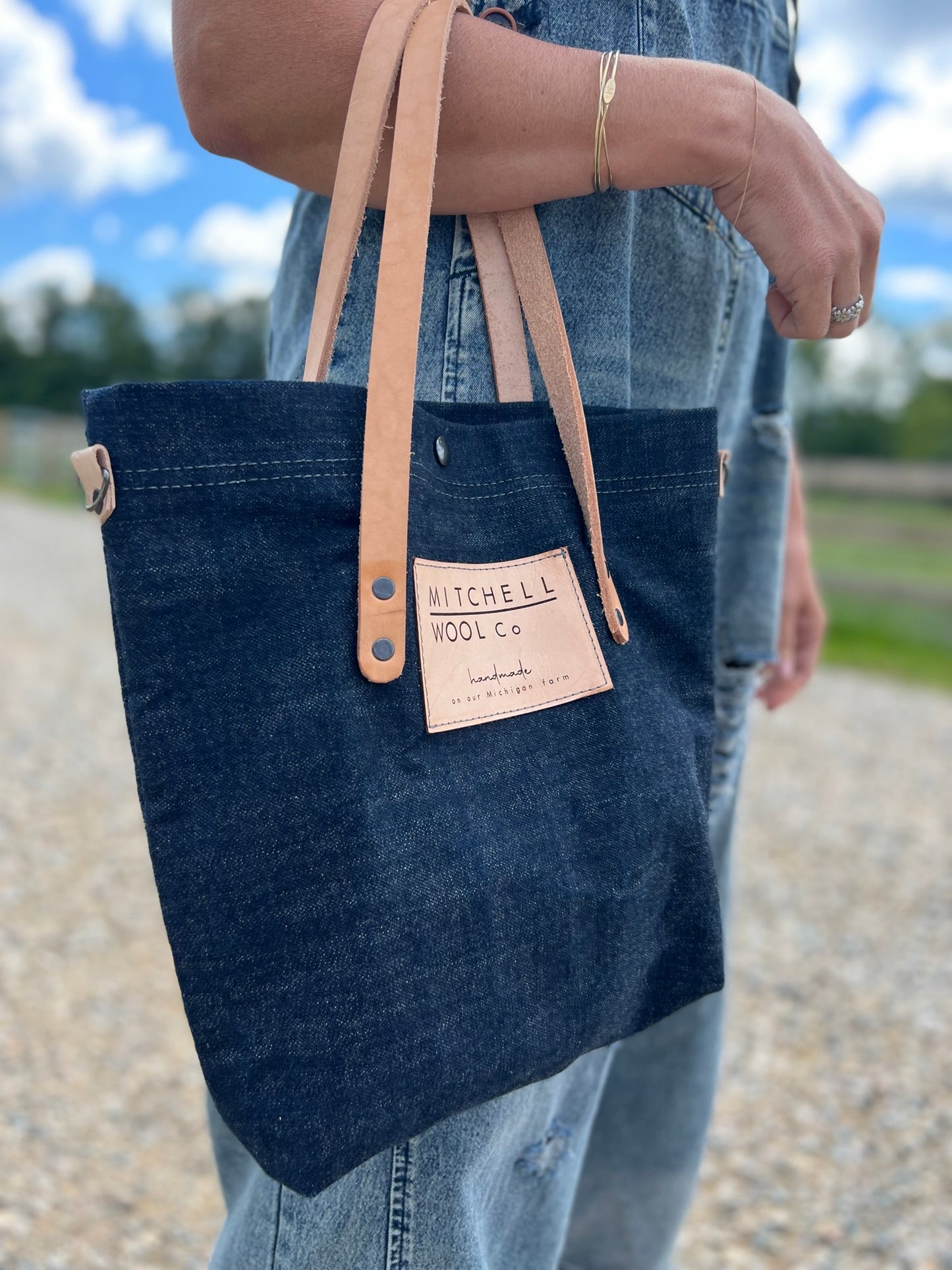 Sherry holds a raw denim Simple tote on her arm